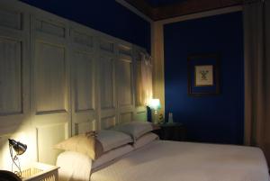 a bedroom with a bed with a blue wall at Kemmare in Riposto