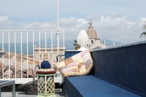 a bench on a balcony with a view of the ocean at Kemmare in Riposto