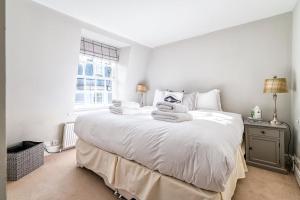 a bedroom with a large white bed with towels on it at Cozy and Spacious Kensington Maisonette in London