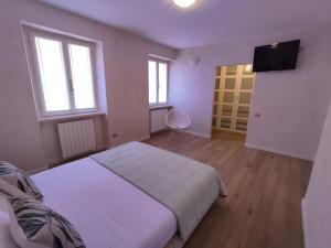 1 dormitorio con 1 cama y TV de pantalla plana en IseoLakeRental - La Filandina, en Riva di Solto