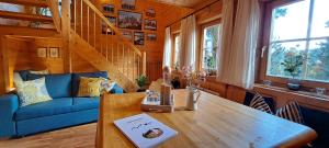 a living room with a table and a blue couch at Chalet Bergliebe Turrach in Turracher Hohe