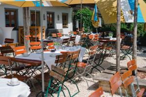 ein Restaurant im Freien mit Tischen, Stühlen und Sonnenschirmen in der Unterkunft Beim Huber in Linden in Linden