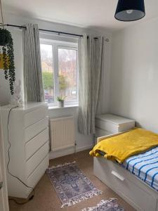 a bedroom with a bed and a dresser and a window at Home from Home sleeps seven in Hastings