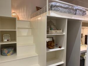 un estante de libros blanco en una habitación en Le Pavillon de Flore by Maison Brasseurs d'Etoiles en Lieja