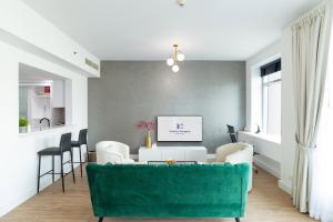 een woonkamer met een groene bank en stoelen bij Full Marina View Luxury 2BR - Park Island Sanibel in Dubai