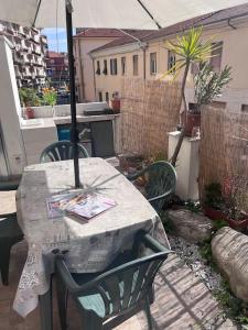 een tafel en stoelen op een patio met een parasol bij La casa del Sole in Imperia