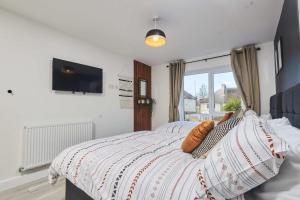 1 dormitorio con 1 cama y TV en la pared en Homebird Property - The Willows, en Leeds
