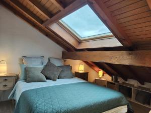 a bedroom with a bed with a large skylight at Charmant Duplex T3 avec Balcon - Halle Olympique in Albertville