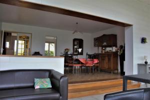 a living room and kitchen with a couch and a table at Gîtes Bellevue et Mascaret in Courtils