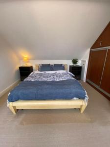 um quarto com uma cama grande e um cobertor azul em Family Relax in the Seaside Town with Parking em Hastings