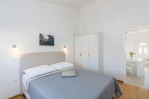 1 dormitorio blanco con 1 cama y armario blanco en Tereza, city central modern apartment, en Novalja