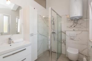 Un baño con inodoro, lavabo y ducha. en Tereza, city central modern apartment, en Novalja 15 fotos más