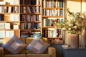 a living room with a couch in front of book shelves at Biarritz Hotel in St. Brelade