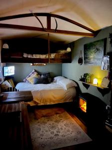 a bedroom with a large bed with a canopy at Mountbatten Shepherds hut & Buckhurst Shepherds hut in Ashford