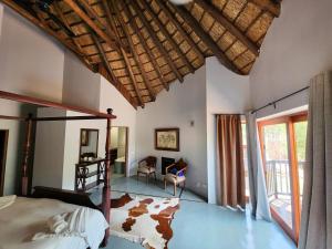 a bedroom with a bed and a desk in a room at Milkwood Safari Lodge in Warmbaths