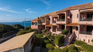 an aerial view of a building with the ocean in the background at La Punta Geronimi in Porto Pollo