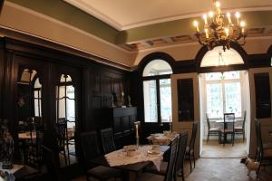 a dining room with tables and chairs and a chandelier at Hotel Villa Victoria in Coburg