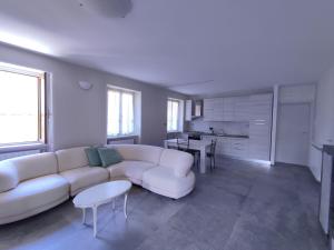 sala de estar con sofá blanco y mesa en IseoLakeRental - La Filandina, en Riva di Solto