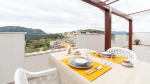 comedor con mesa, sillas y ventana en Welcomely - Appartamento Nuraghe Tanca Manna, en Nuoro