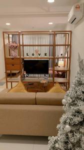 a living room with a couch and a christmas tree at Familia Holiday @ TimurBay Seafront Kuantan in Kuantan