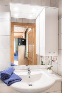 ein Bad mit einem Waschbecken und einem Spiegel in der Unterkunft Hallmoosgut in St. Johann im Pongau