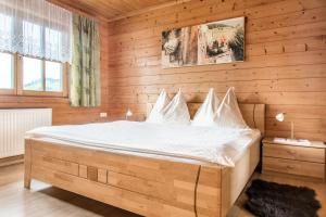 een slaapkamer met een bed in een houten kamer bij Hallmoosgut in Sankt Johann im Pongau