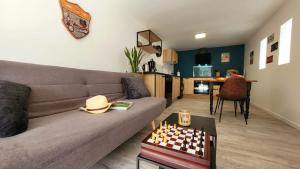 a living room with a couch and a chess board at Entre Ciel et Verdon in Castellane