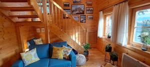 a living room with a blue couch and a staircase at Chalet Bergliebe Turrach in Turracher Hohe