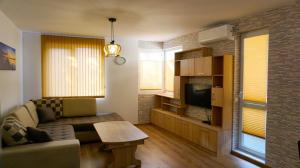 ein Wohnzimmer mit einem Sofa und einem TV in der Unterkunft Апартамент Далия - Apartment Dalia in Warna