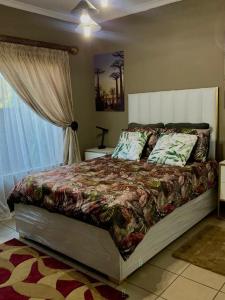 a bedroom with a bed with a large window at East Cottage in Boksburg