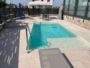uma piscina com mesa e cadeiras ao lado em CASA DANZI em Peschiera del Garda