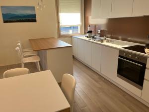 a kitchen with white cabinets and a table and a sink at CASA DANZI in Peschiera del Garda