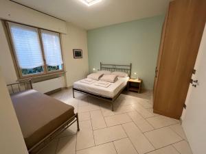 a bedroom with a bed and a table and two windows at CASA DANZI in Peschiera del Garda