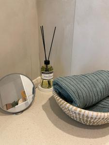 a mirror sitting next to a basket with a blanket at Studio Delfien in Oostduinkerke