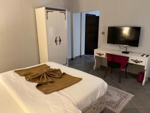 阿克拉的住宿－Euro Homes Hotel，一间卧室配有一张床、一张书桌和一台电视
