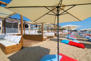 ein Strand mit vielen Liegen und Sonnenschirmen auf dem Sand in der Unterkunft Апартамент Далия - Apartment Dalia in Warna