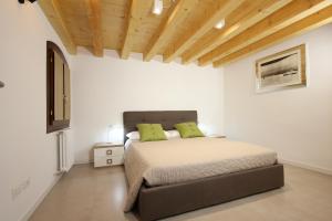 um quarto com uma cama com duas almofadas verdes em Ca' Puccetti em Veneza