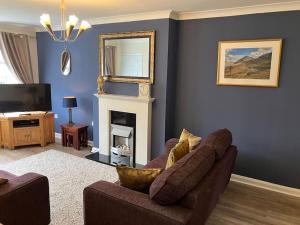 a living room with a couch and a fireplace at Ogilvie Lodge in Llandudno Junction