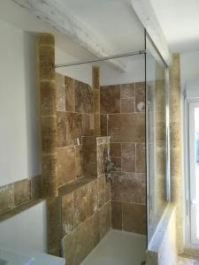 La salle de bains est pourvue d'une douche avec une porte en verre. dans l'établissement Mas des jours heureux aigues mortes, à Aigues-Mortes