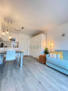 een woonkamer met een blauwe bank en een tafel bij Studio Delfien in Oostduinkerke