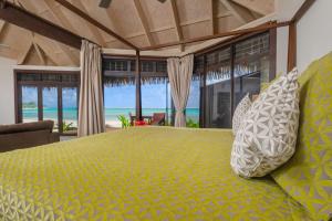 1 dormitorio con 1 cama y vistas al océano en Sea Change Villas en Rarotonga