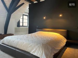 una camera da letto con un grande letto con lenzuola bianche di Peter House a Nivelles