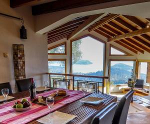 comedor con mesa y ventana grande en Casa Karine - Vue imprenable et dolce vita en San Carlos de Bariloche