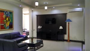 a living room with a couch and a big screen tv at MAXI HOTEL KEDONGANAN in Kuta