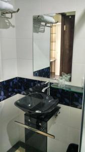 a bathroom with a black sink and a mirror at MAXI HOTEL KEDONGANAN in Kuta