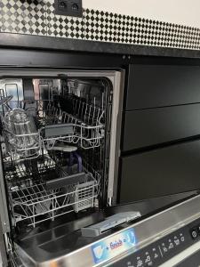 a dishwasher with a dish rack inside of it at Peter House in Nivelles