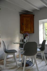 a dining room with four chairs and a table at Cotswolds Corner Cottage in Moreton in Marsh