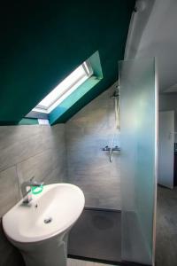 a bathroom with a white sink and a shower at Cotswolds Corner Cottage in Moreton in Marsh