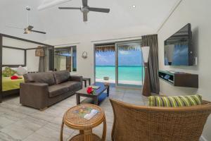 a living room with a couch and a tv at Sea Change Villas in Rarotonga