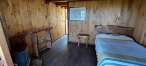 a room with two beds in a wooden cabin at Cabaña en el Bosque de San José del Pacífico in El Pacífico